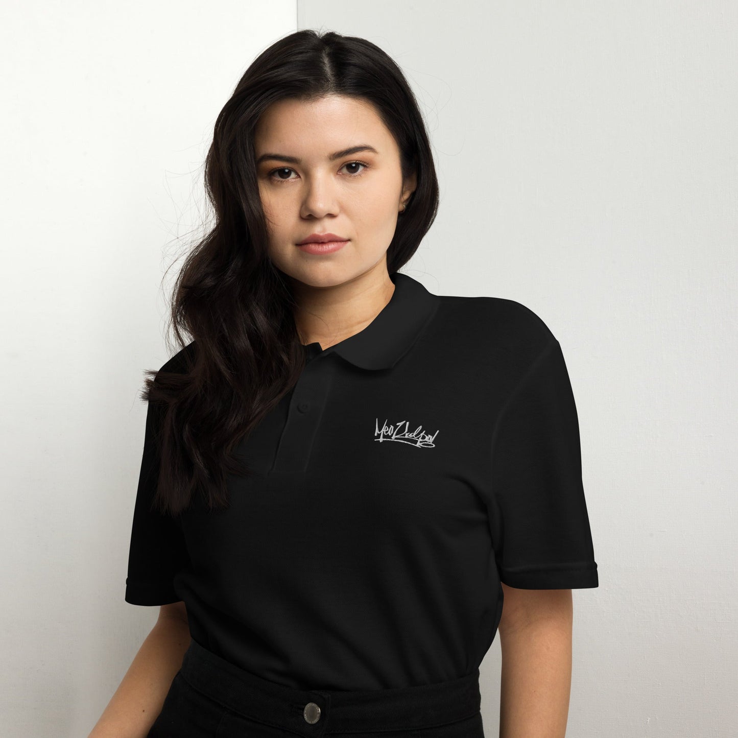 Girl with dark hair wearing Polo.Make a statement in timeless black with the MeaKulpa Unisex Pique Polo Shirt. Crafted from durable ring-spun cotton, this shirt offers a comfortable and flattering fit. Its classic cut and crisp collar ensure versatility, allowing you to dress it up or down with ease. Perfect for both casual and formal occasions, this black polo exudes sophistication and style.