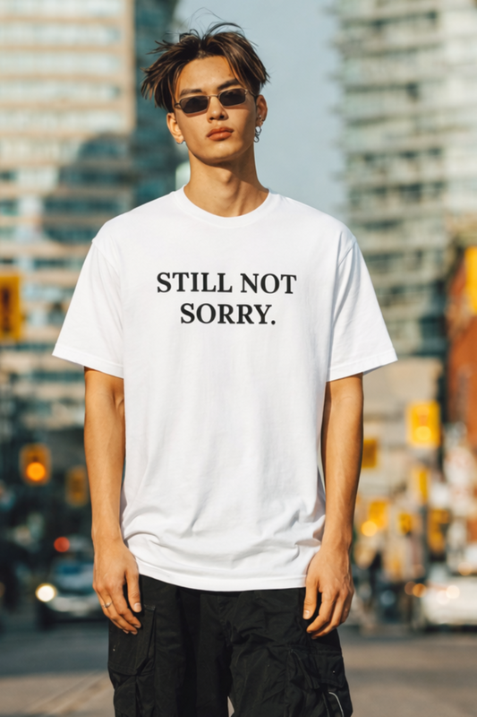 Gen Z man wearing a white t-shirt with 'STILL NOT SORRY.' text in an urban setting